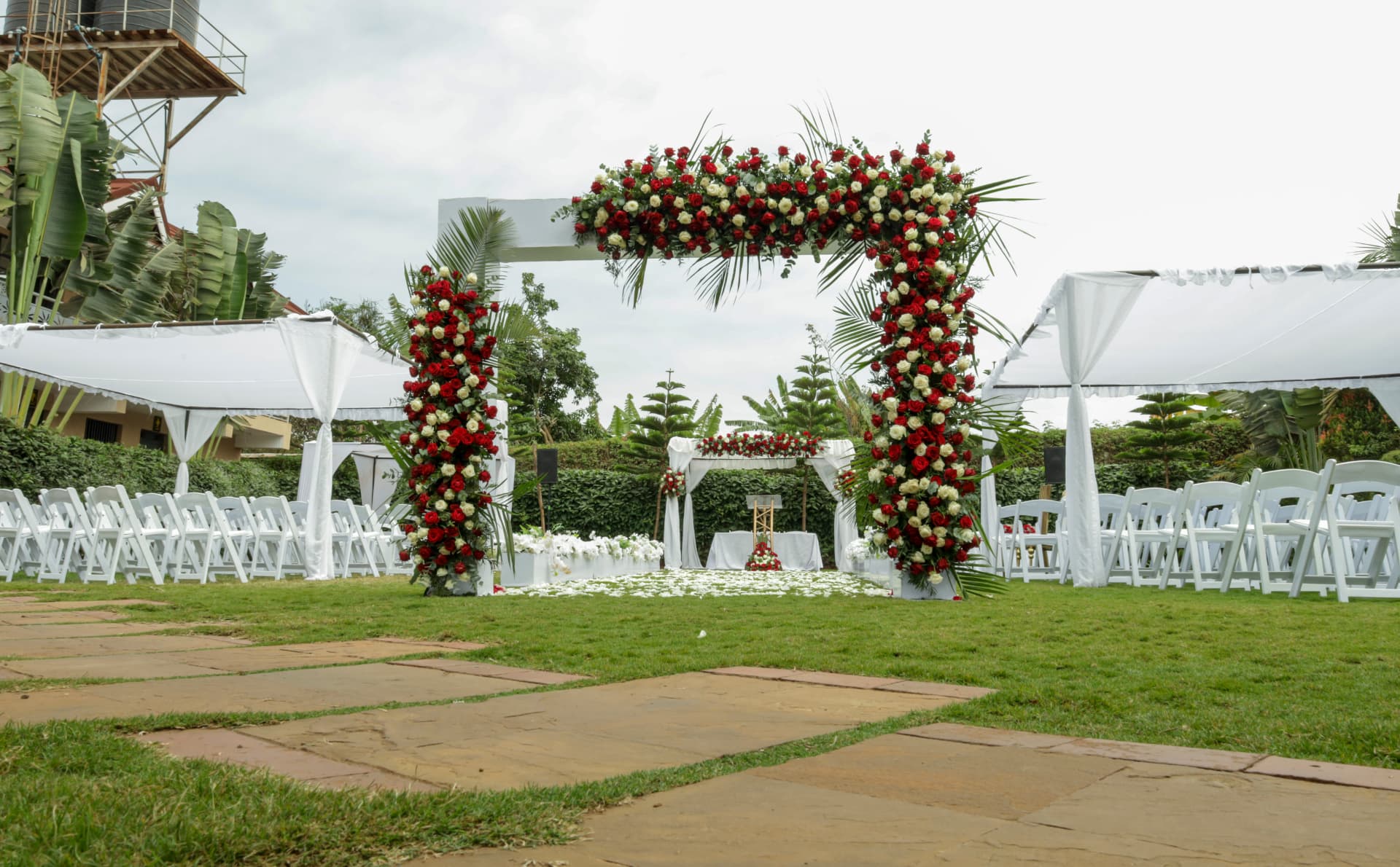 Red and white floral arch with outdoor guest seating