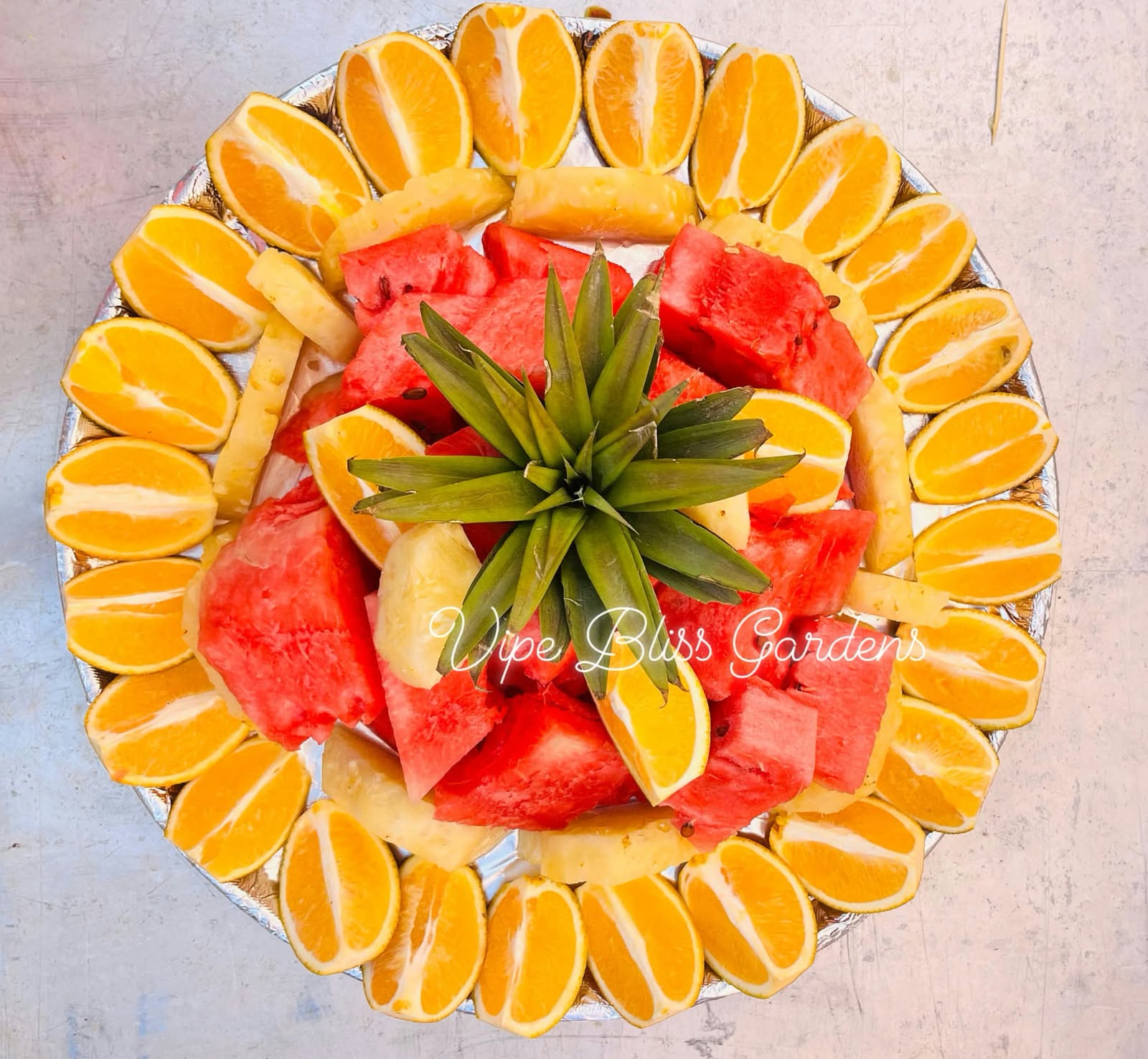 Colourful fruit platter with orange wedges, watermelon and pineapple